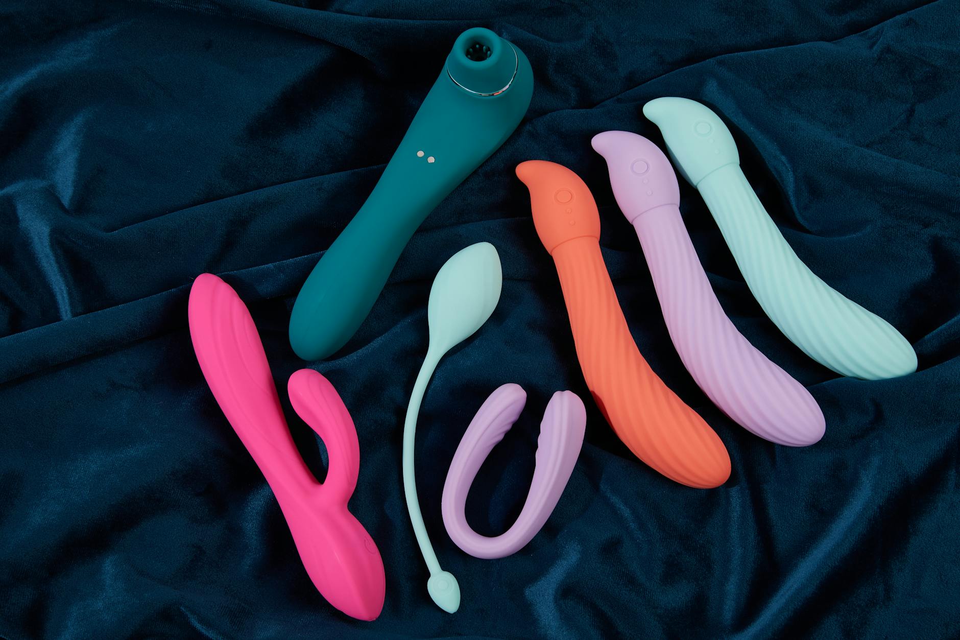 Eine Frau hält einen blauen und rosa Zitronenvibrator nachdenklich in den Händen