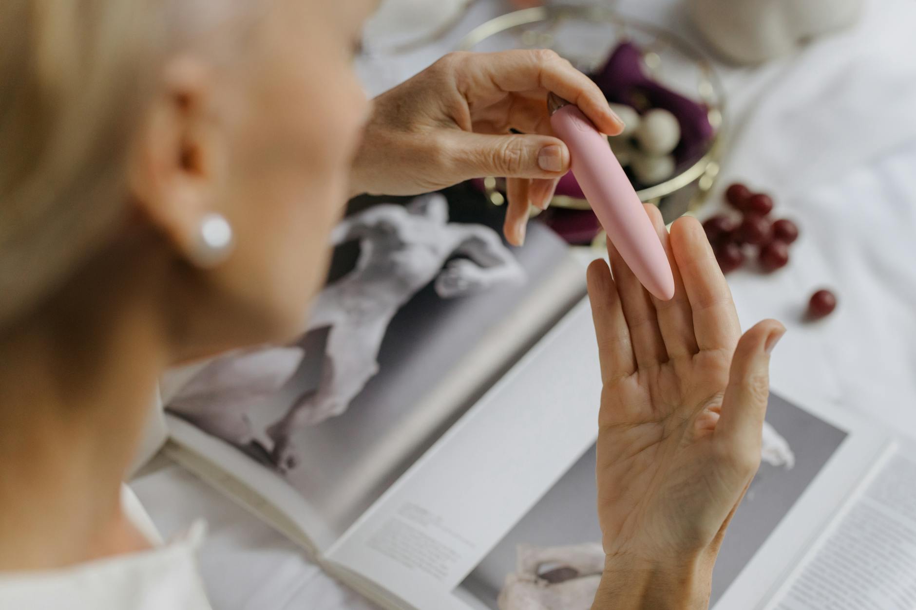 Woman holding two colorful vibrators, representing choices in clitoral stimulation